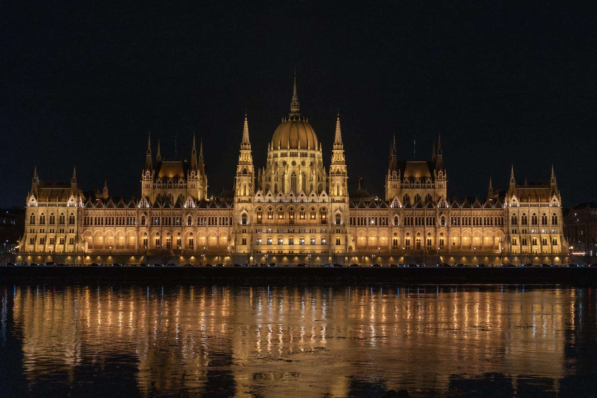 Das ungarische Parlament in Budapest bei Nacht, gespiegelt in der Donau
